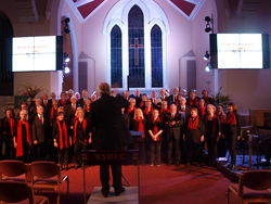 Ian Allen (l.) dirigiert die Chöre aus Rinteln und Kendal beim großen Finale des gemeinsamen Konzerts in der Kendaler Kirche St. Thomas. Foto: dil