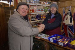 Liz Cooke vom WOSP-Stand beim Weihnachtsmarkt der Lebenshilfe Rinteln und Dietrich Lange, Vorsitzender des Rintelner Vereins für Städtepartnerschaften (links) genießen eine Tasse heißen Tee. Foto: Werner Hoppe