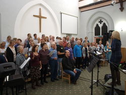 Bei der öffentlichen gemeinsamen Chorprobe im Church Centre von Bowness (hier mit Dirigentin Diane France rechts) verschmelzen der Gospelchor "Gospelicious" aus Rinteln und der Lakee Gospel Choir sängerisch in perfekter Harmonie miteinander. Foto: Lange