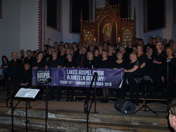 Schlussbild mit Werbebanner: Die Chöre "Gospelicious", "Sing and Pray" und der Lakes Gospel Choir in der Steinberger Kirche. Foto: Lange