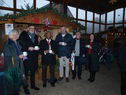 Tea time am Stand der Kendaler Behindertenbetreuung WOSP beim Weihnachtsmarkt der Lebenshilfe: Die Bürgermeister Thomas Priemer und Guy Tirvengadum genießen mit Gästen das Heißgetränk. Foto: dil